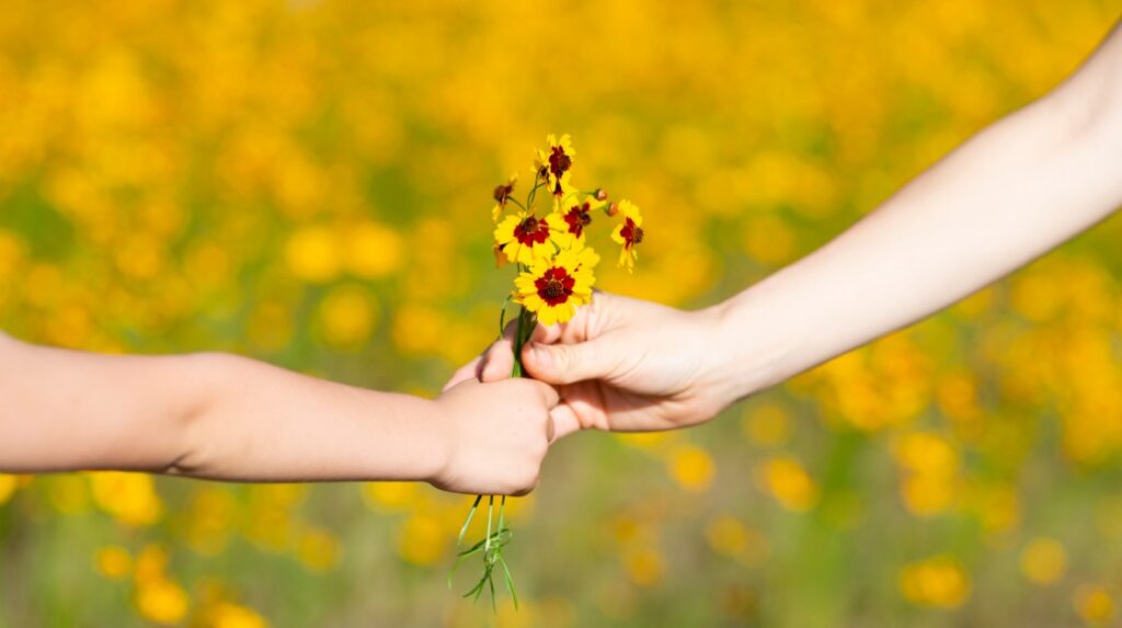 Child giving a flower to a parent as a gesture of gratitude
